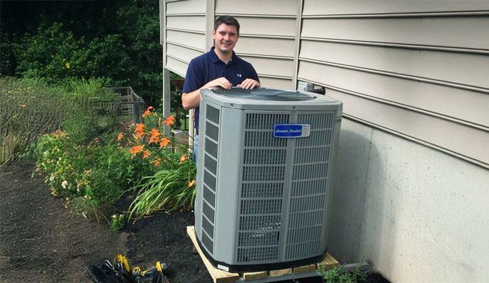 Professional technician standing with HVAC outdoor unit