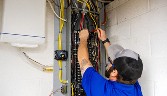 Electrician testing a main home electrical panel box.