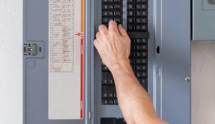 Person adjusting switches inside a electrical breaker panel