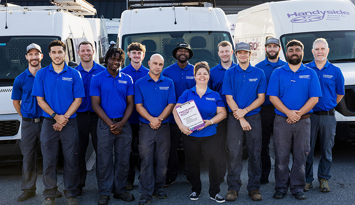 Handyside service team posing in front of a their vehicles
