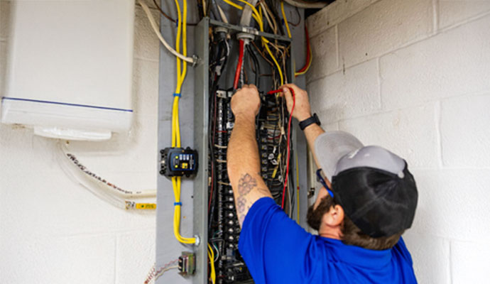 Electrician testing a main home electrical panel box.