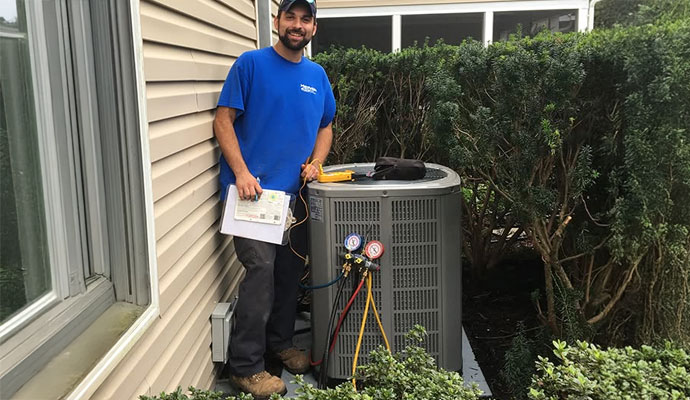 Technician performing HVAC maintenance on an outdoor unit.