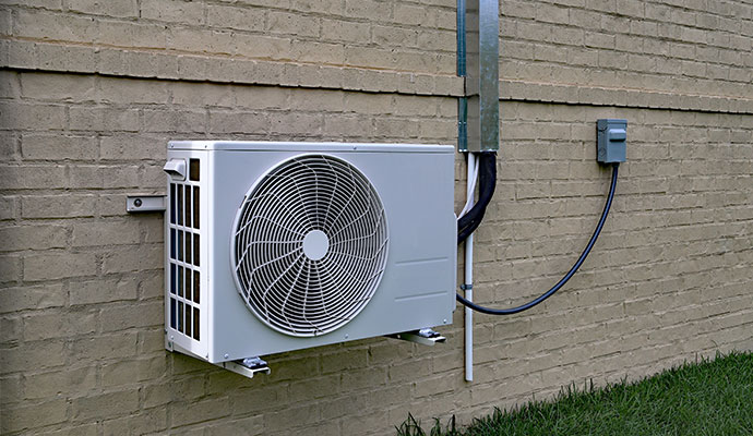Outdoor ductless mini-split AC unit installed on a wall.